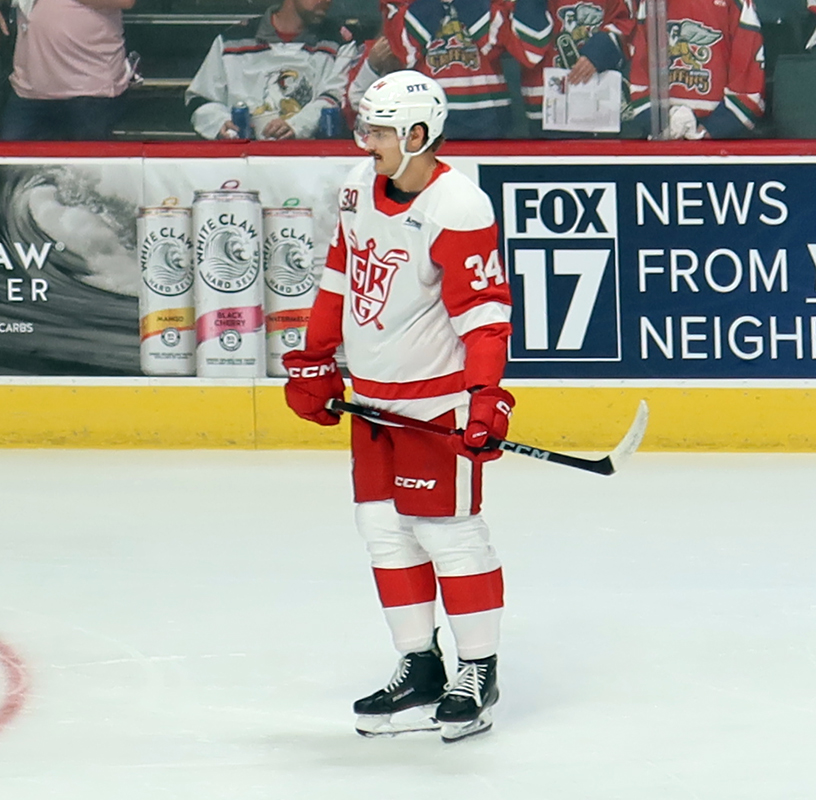 Eduards Tralmaks of the Grand Rapids Griffins skates near the boards during pre-game warmups before a game against the Manitoba Moose.