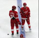 Moritz Seider and Jacob Bernard-Docker of the Detroit Red Wings stand at the blue line during pre-game warmups before a game against the Carolina Hurricanes, wearing customized Sergei Fedorov jerseys and white skates in honor of Fedorov's jersey retirement.