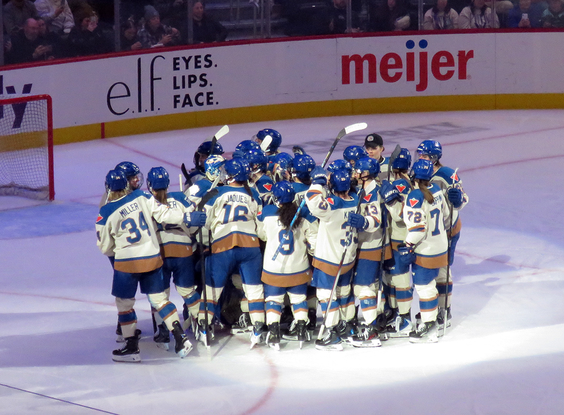 The Vancouver Goldeneyes gather in front of their goal to celebrate a win over the Boston Fleet in the PWHL Takeover Tour Detroit game.