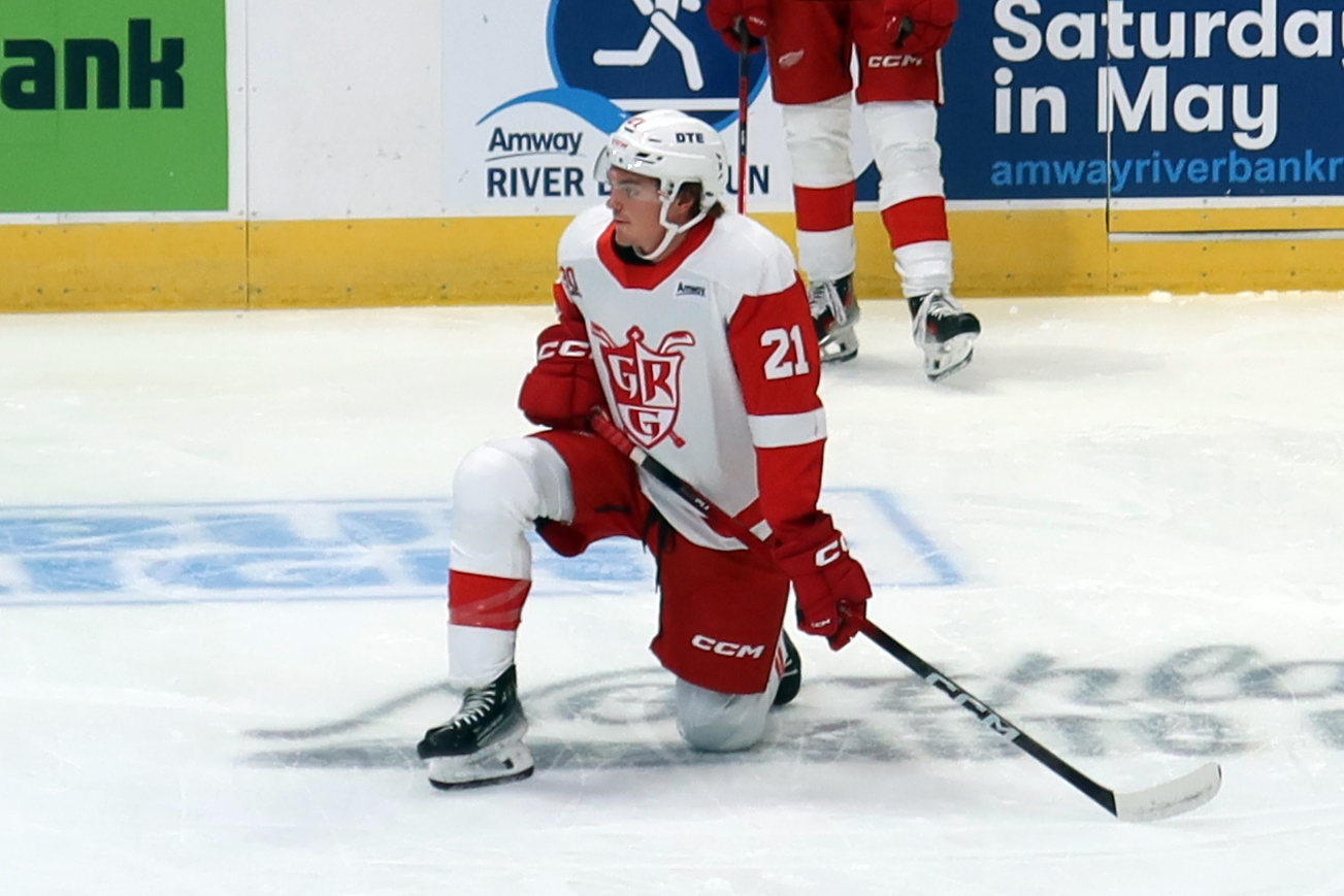 Carson Bantle of the Grand Rapids Griffins kneels near the boards during pre-game warmups before a game against the Manitoba Moose.