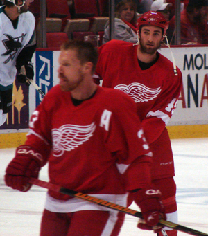 Kyle Quincey watches his teammates during pregame warmups as Kris Draper passes in front of him.