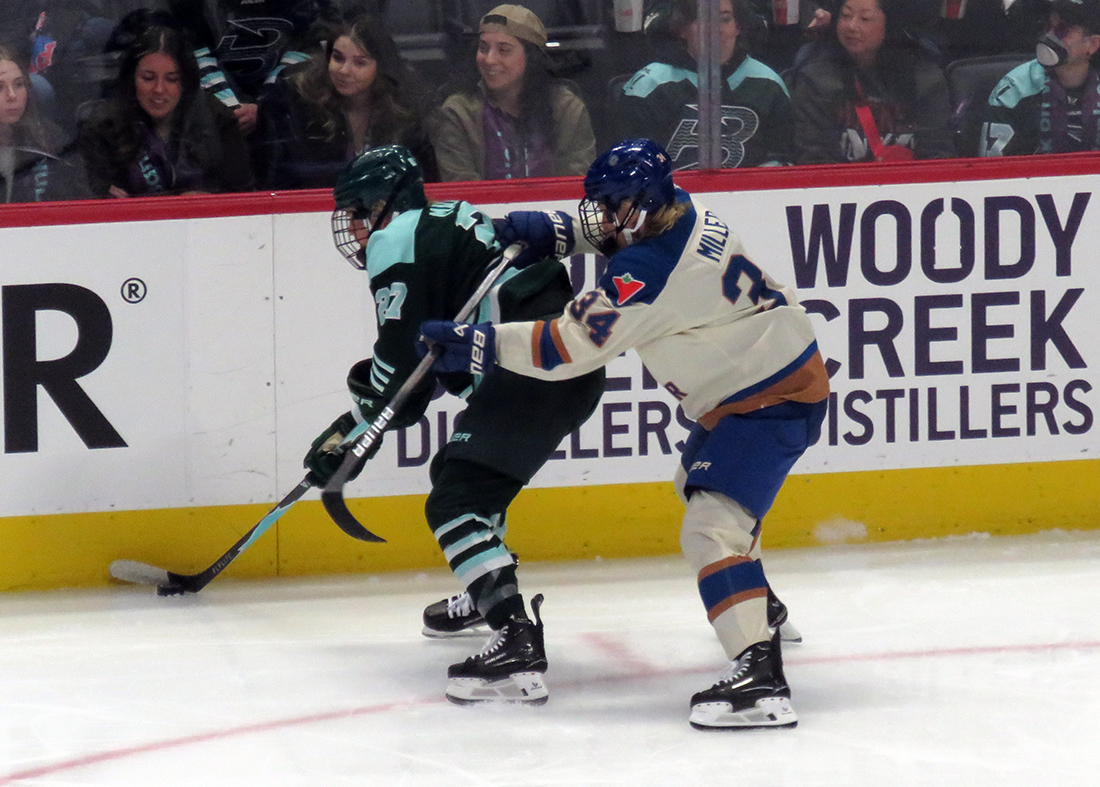 Shay Maloney of the Boston Fleet and Hannah Miller of the Vancouver Goldeneyes fight for position near the boards during the PWHL Takeover Tour Detroit game.