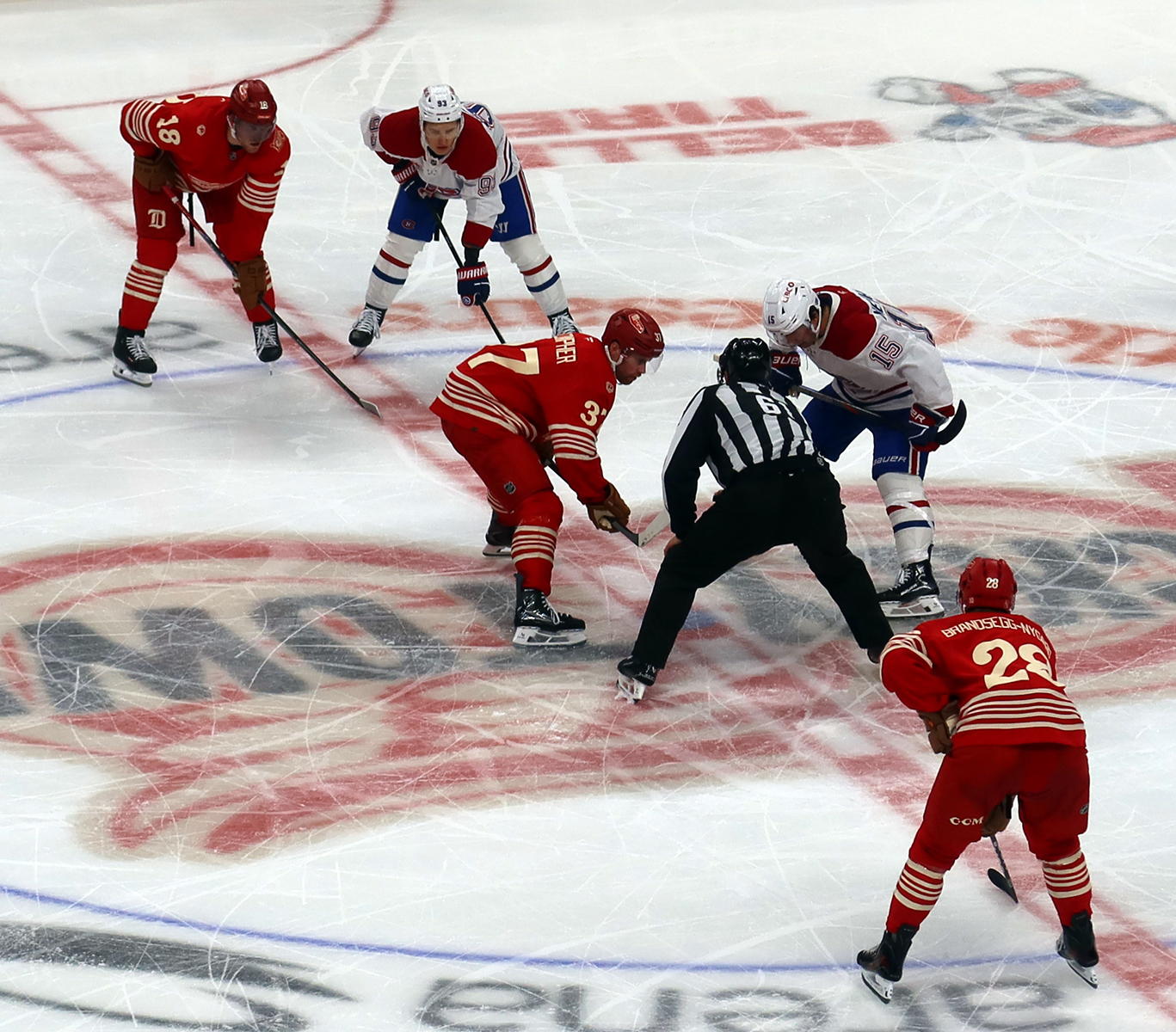 The Detroit Red Wings and Montreal Canadiens line up for a faceoff, with J.T. Compher, Andrew Copp, and Michael Brandsegg-Nygard of Detroit opposite Alex Newhook and Ivan Demidov of Montreal.