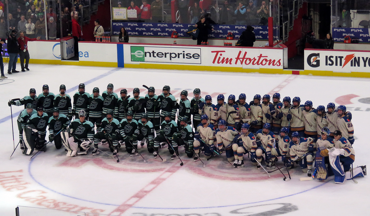The Boston Fleet and Vancouver Goldeneyes pose at center ice for a group photo after the PWHL Takeover Tour Detroit game.