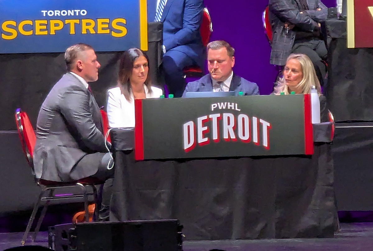 The PWHL Detroit delegation at the 2026 PWHL Entry Draft; goaltending coach Jimmy Howard, general manager Manon Rheaume, head coach Josh Sciba, and consultant Ellen Hughes.