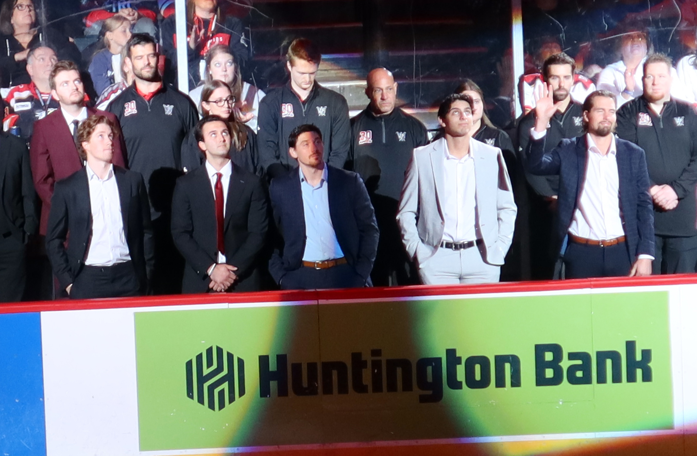 Grand Rapids Griffins Nate Danielson, Jacob Truscott, John Leonard, Shai Buium, and Justin Holl stand at the bench while being introduced as scratches before the team's home opener against the Manitoba Moose.