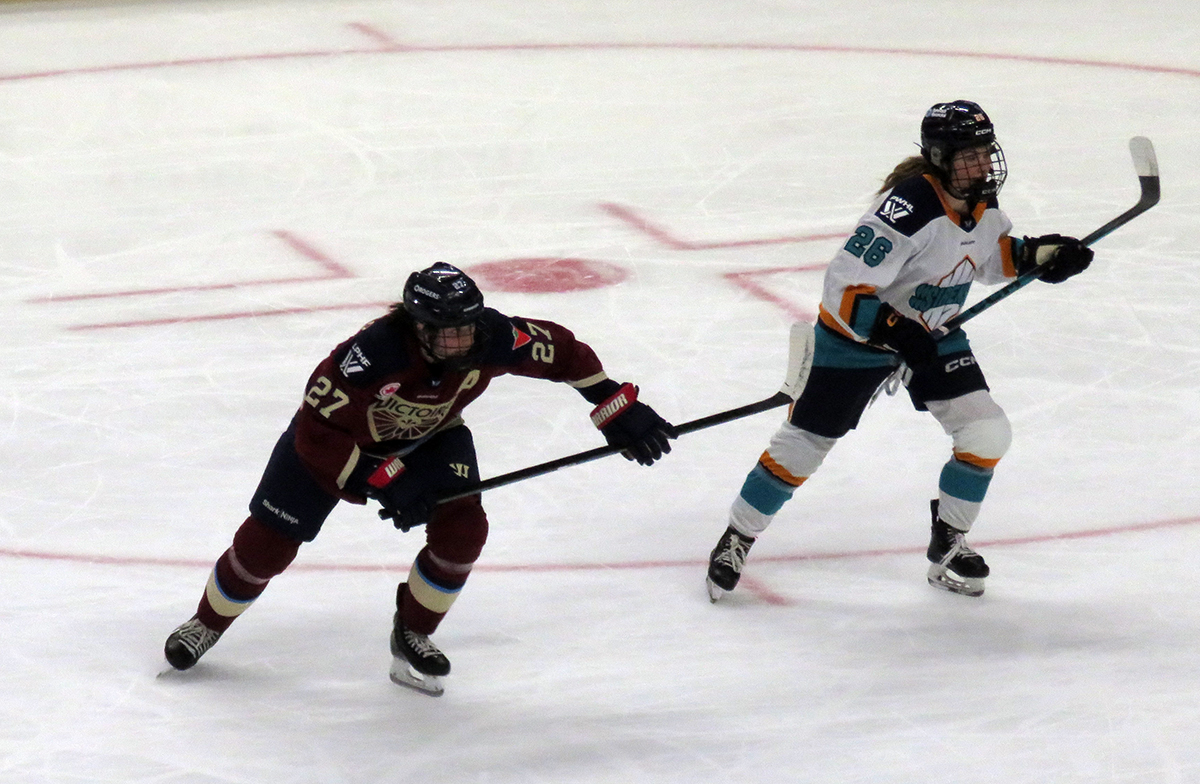 Shiann Darkangelo of the Montreal Victoire and Casey O'Brien of the New York Sirens skate up ice the PWHL Takeover Tour Detroit game.