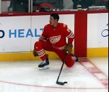 Travis Hamonic of the Detroit Red Wings stretches near the boards during pre-game warmups before a game against the Montreal Canadiens.