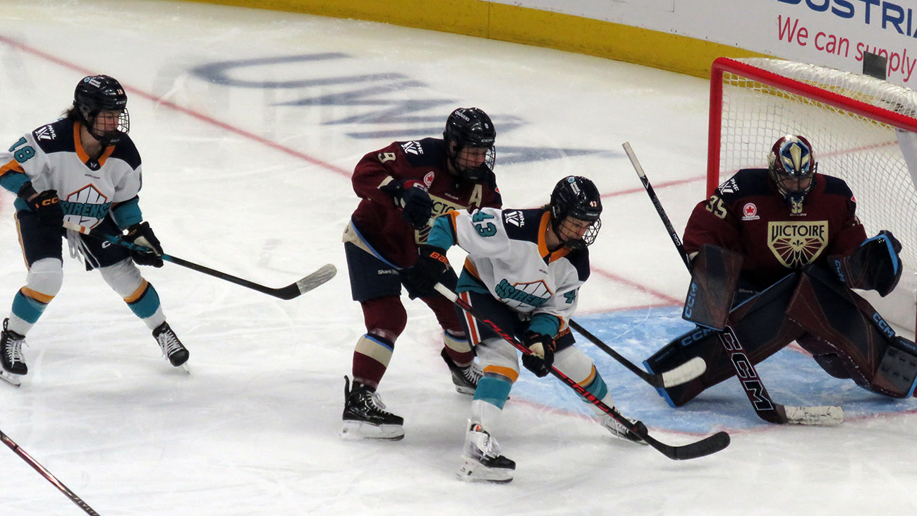 Maddi Wheeler and Kristin O'Neill of the New York Sirens battle for position at the top of the crease with Kati Tabin and goalie Ann-Renee Desbiens of the Montreal Victoire during the PWHL Takeover Tour Detroit game.