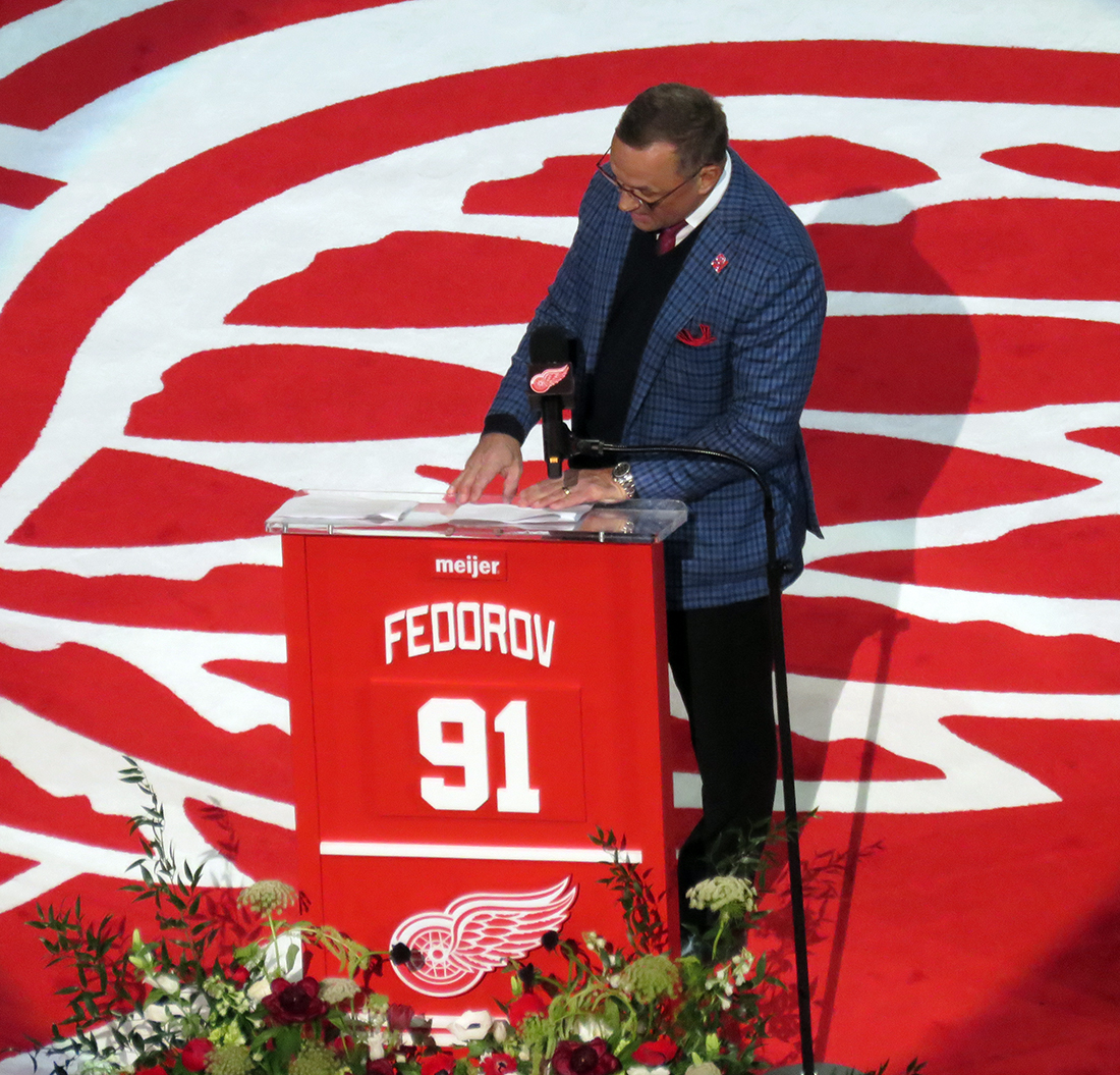 Steve Yzerman invites Sergei Fedorov to the podium at Fedorov's jersey retirement ceremony.