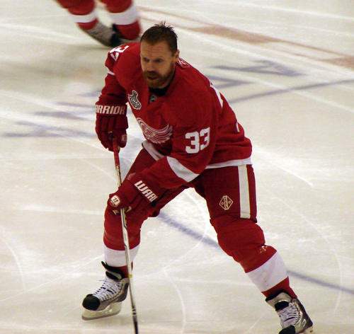 Kris Draper picks up a puck in the neutral zone during pre-game warmups.