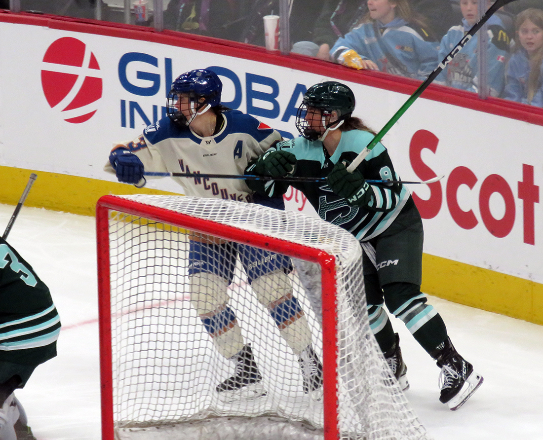 Michelle Karvinen of the Vancouver Goldeneyes and Haley Winn of the Boston Fleet battle for position behind the Boston net during the PWHL Takeover Tour Detroit game.