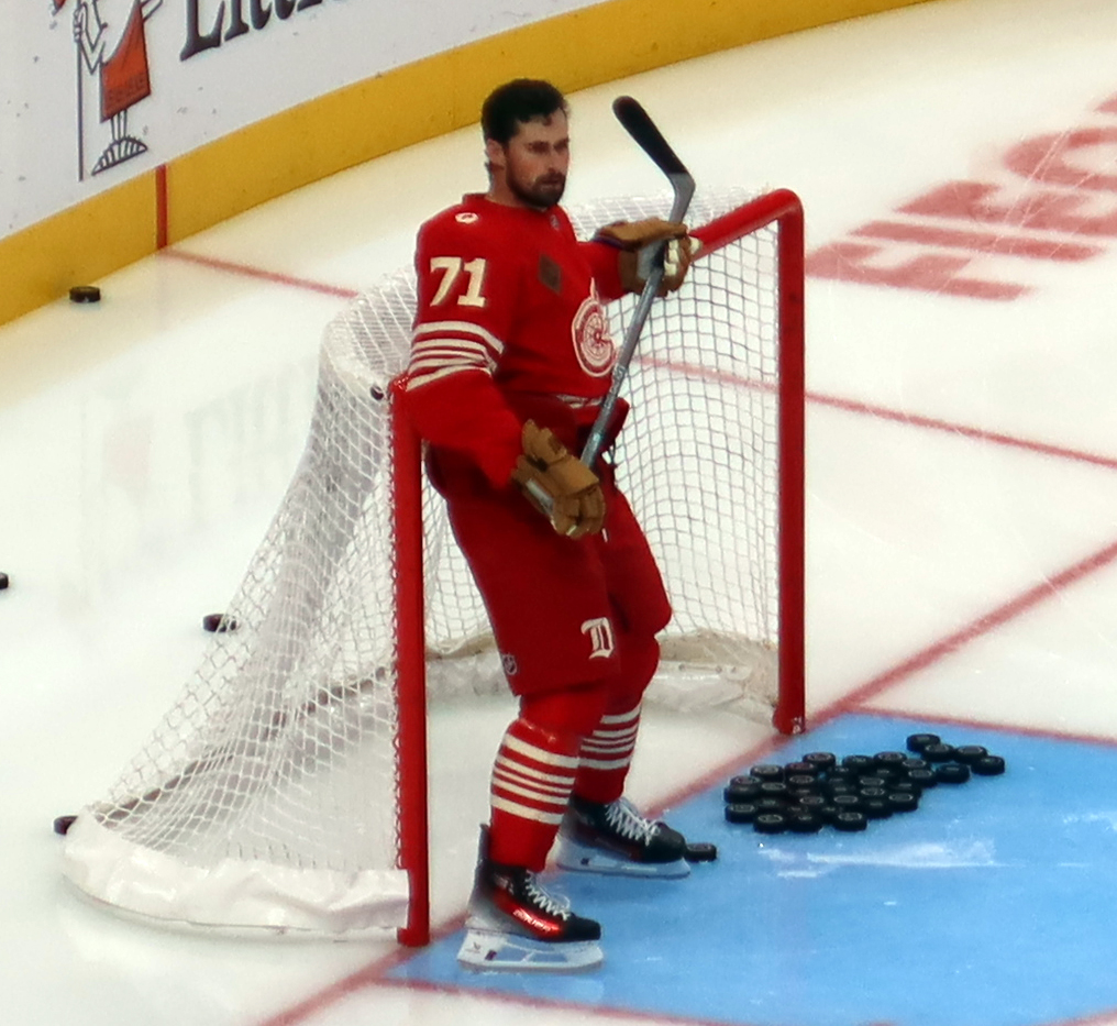 Dylan Larkin of the Detroit Red Wings clears pucks out of the net during pre-game warmups before a game against the Montreal Canadiens.