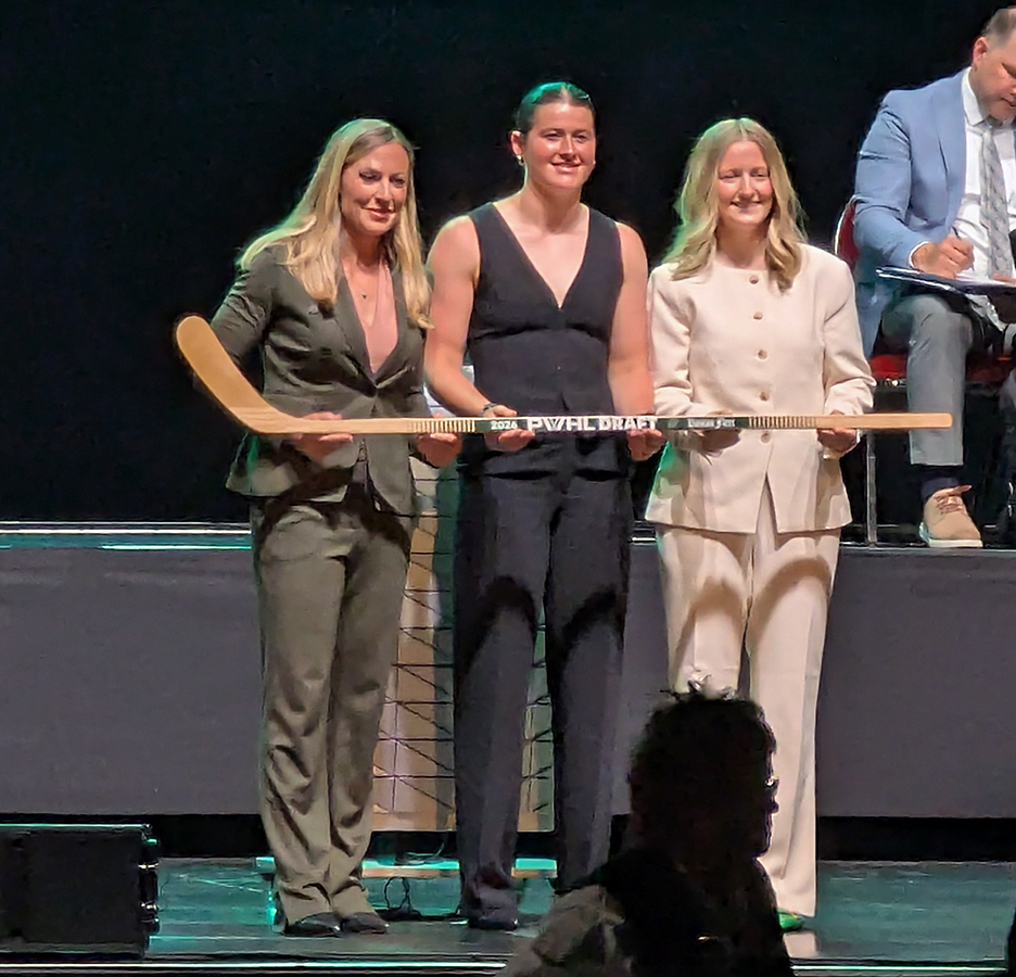 Grace Dwyer is selected tenth overall at the 2026 PWHL Entry Draft, flanked by PWHL senior vice president Jayna Hefford and Boston Fleet general manager Danielle Marmer.