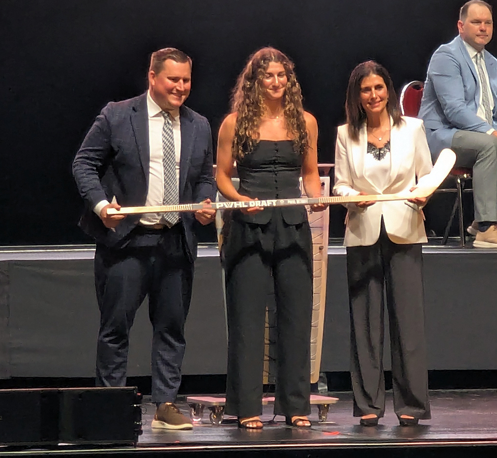 Georgia Schiff is selected in the sixth round of the 2026 PWHL Entry Draft, flanked by PWHL Detroit head coach Josh Sciba and general manager Manon Rheaume.