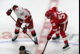 Andrei Svechnikov of the Carolina Hurricanes and Emmitt Finnie of the Detroit Red Wings line up at wing for a faceoff.