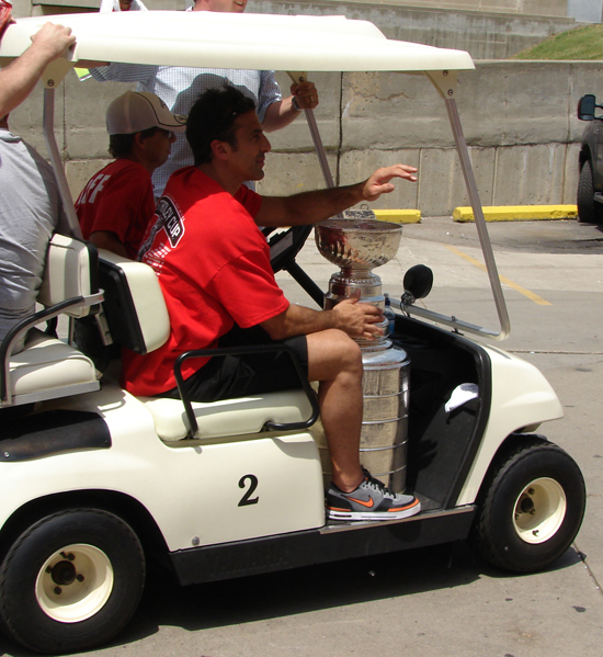 Chris Chelios returns to Joe Louis Arena from Hart Plaza in a golf cart with the Stanley Cup.