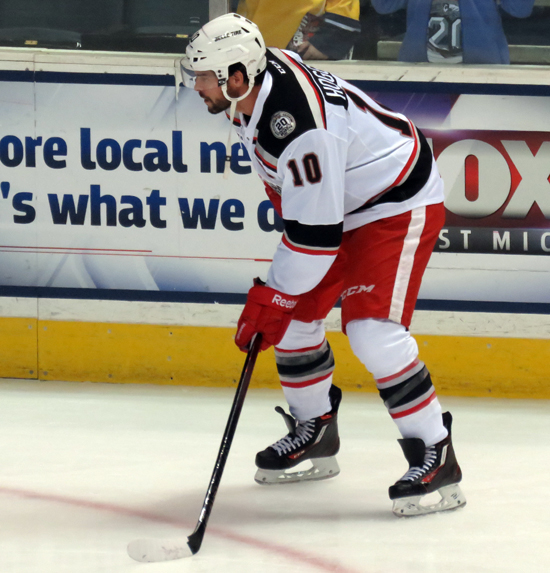 Jeff Hoggan crouches near the boards during pre-game warmups before a Grand Rapids Griffins game.