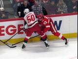 Eric Robinson of the Carolina Hurricanes and Moritz Seider of the Detroit Red Wings battle along the boards.
