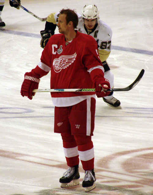 Nicklas Lidstrom stands at center ice during pre-game warmups as Pittsburgh captain Sidney Crosby skates behind him.