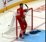 Dylan Larkin of the Detroit Red Wings clears pucks out of the net during pre-game warmups before a game against the Montreal Canadiens.