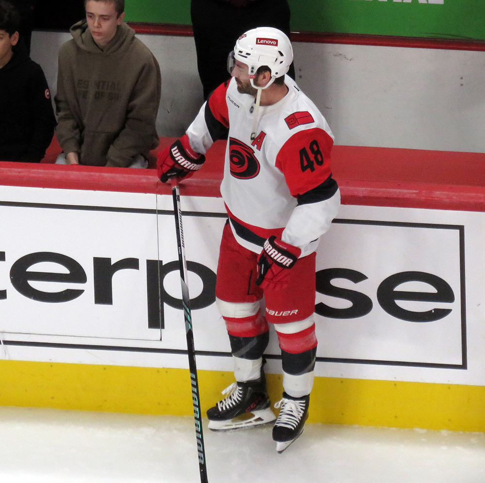 Jordan Martinook of the Carolina Hurricanes stands at the bench during pre-game warmups before a game against the Detroit Red Wings.