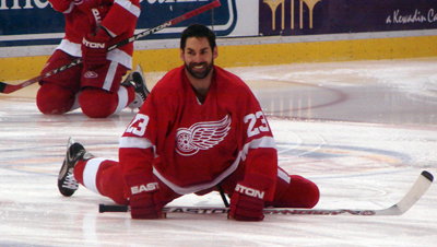 Mathieu Schneider stretches in the neutral zone during pregame warmups.