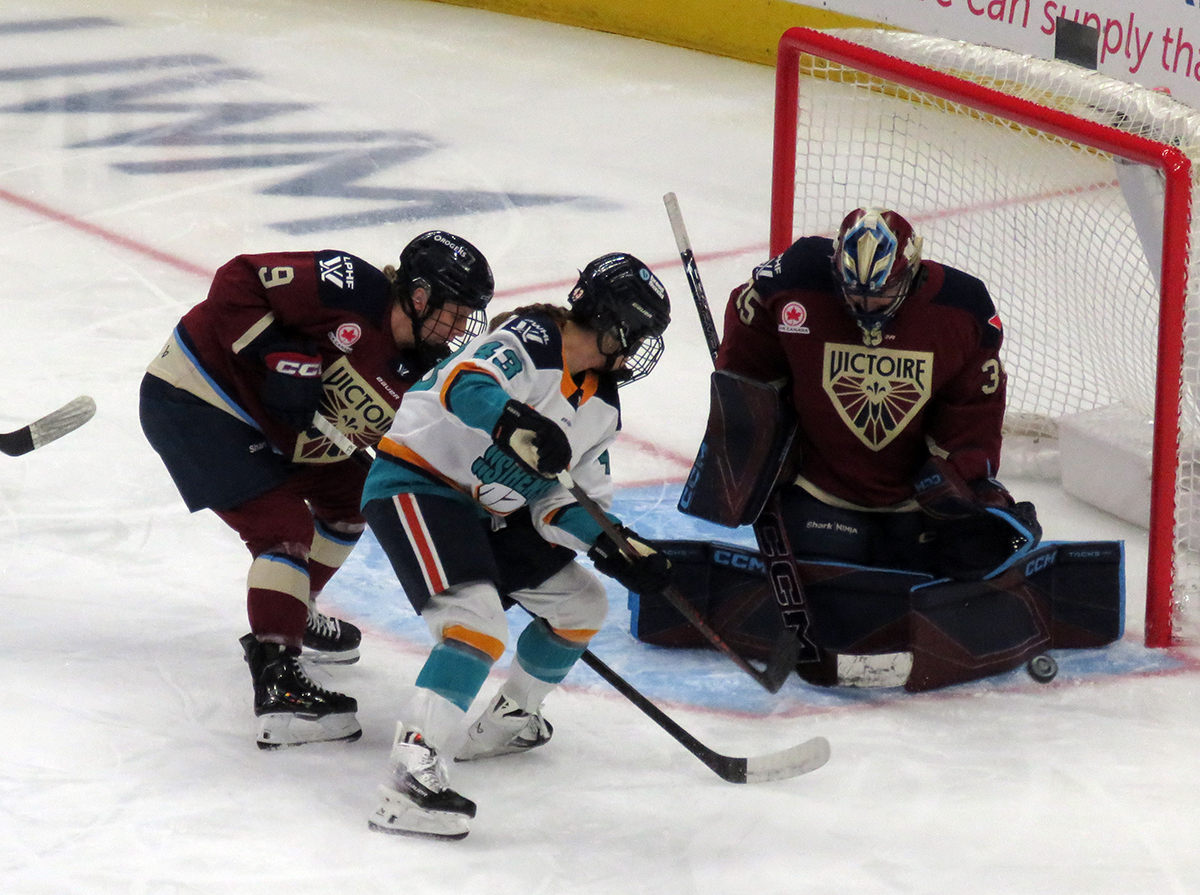 Kristin O'Neill of the New York Sirens takes a shot on goalie Ann-Renee Desbiens of the Montreal Victoire while being defended by Kati Tabin during the PWHL Takeover Tour Detroit game.