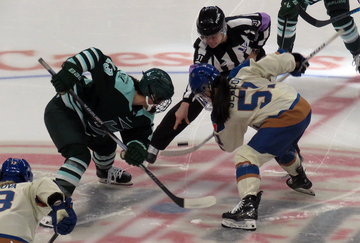 Liz Schepers of the Boston Fleet and Anna Segedi of the Vancouver Goldeneyes take a faceoff during the PWHL Takeover Tour Detroit game.