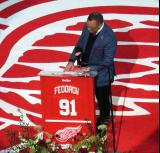 Steve Yzerman invites Sergei Fedorov to the podium at Fedorov's jersey retirement ceremony.
